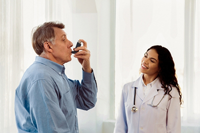 Physician providing advanced asthma care to senior man during clinic visit