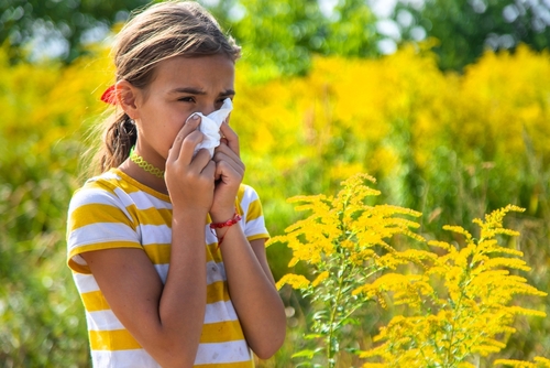 Child outdoors showing symptoms of pollen allergy