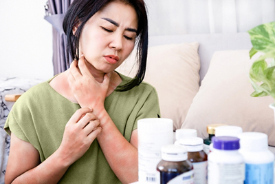 A woman experiencing a rash flare-up after taking medication, showing signs of an allergic skin reaction or drug sensitivity